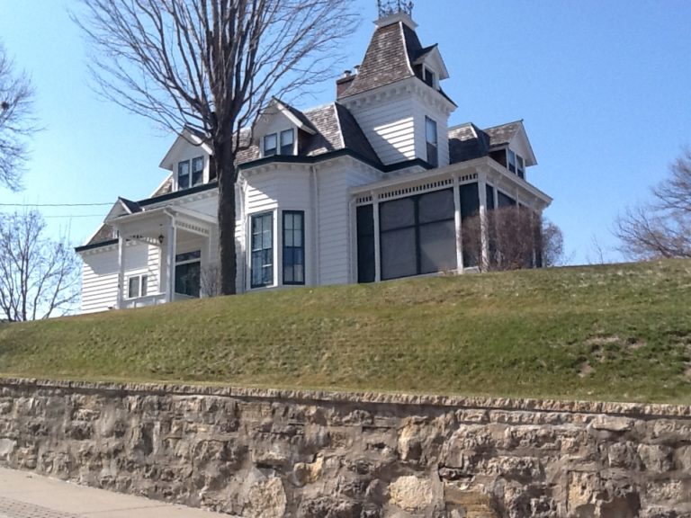 Large Victorian style house on a hill newly painted white