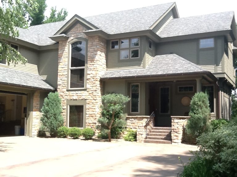 Large home with stone features and newly painted siding and trim